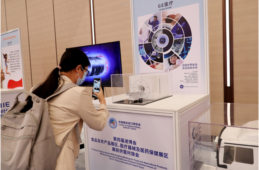 第四屆進(jìn)博會(huì)食品及農(nóng)產(chǎn)品展區(qū)、醫(yī)療器械及醫(yī)藥保健展區(qū)展前供需對接會(huì)的參會(huì)嘉賓用手機(jī)拍攝參展企業(yè)的展品模型